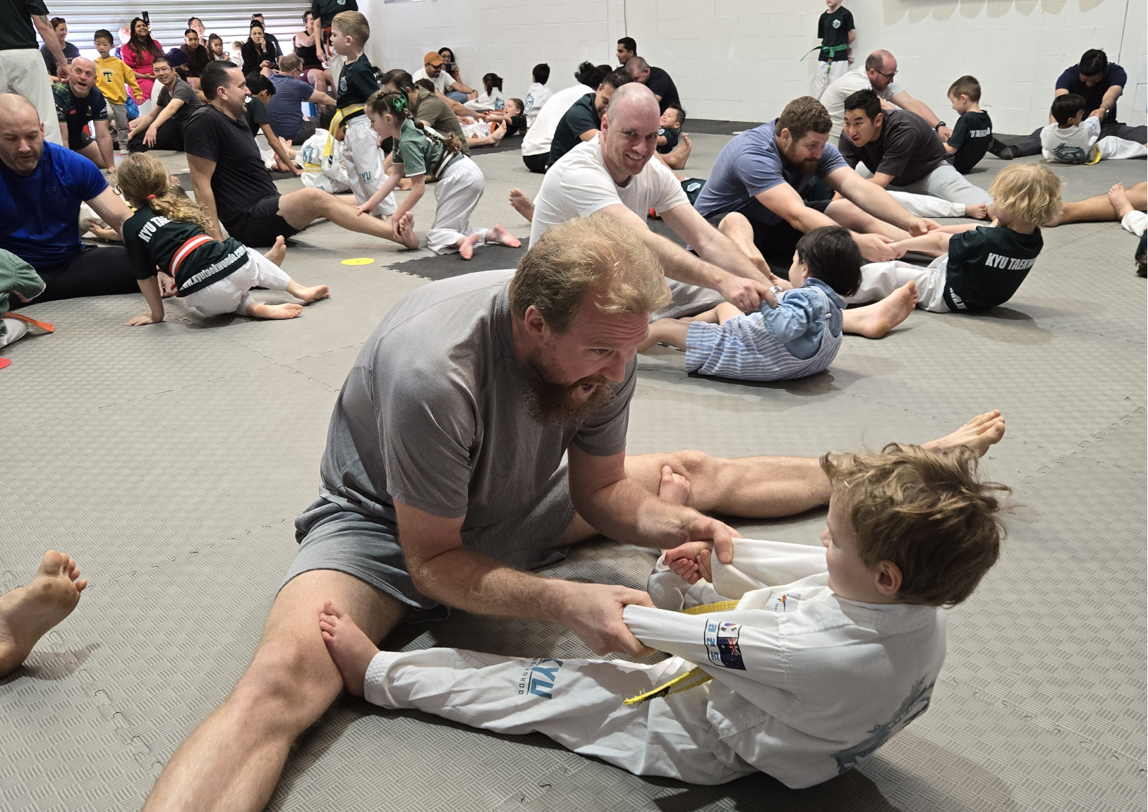 Families training together in supportive Taekwondo environment